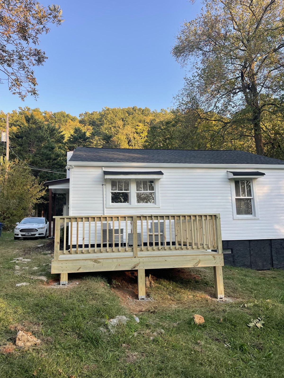 Low 12x12 wood deck with railing on the back of a house